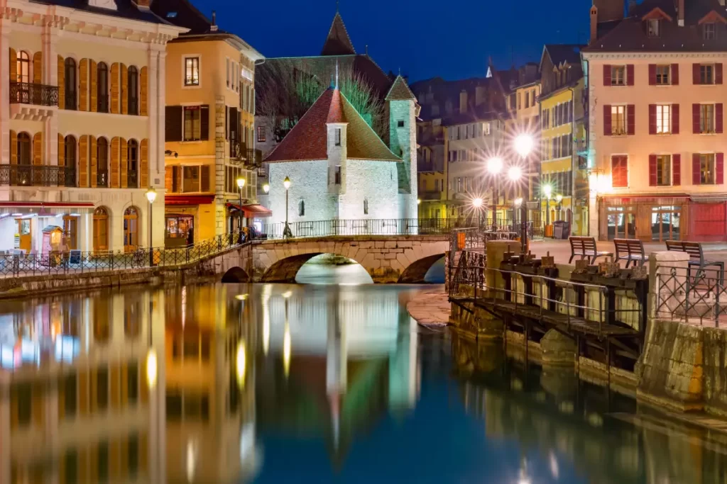 Night view of the Annecy canals and the Palais de l'Isle, close to the Hôtel Palais de l'Isle