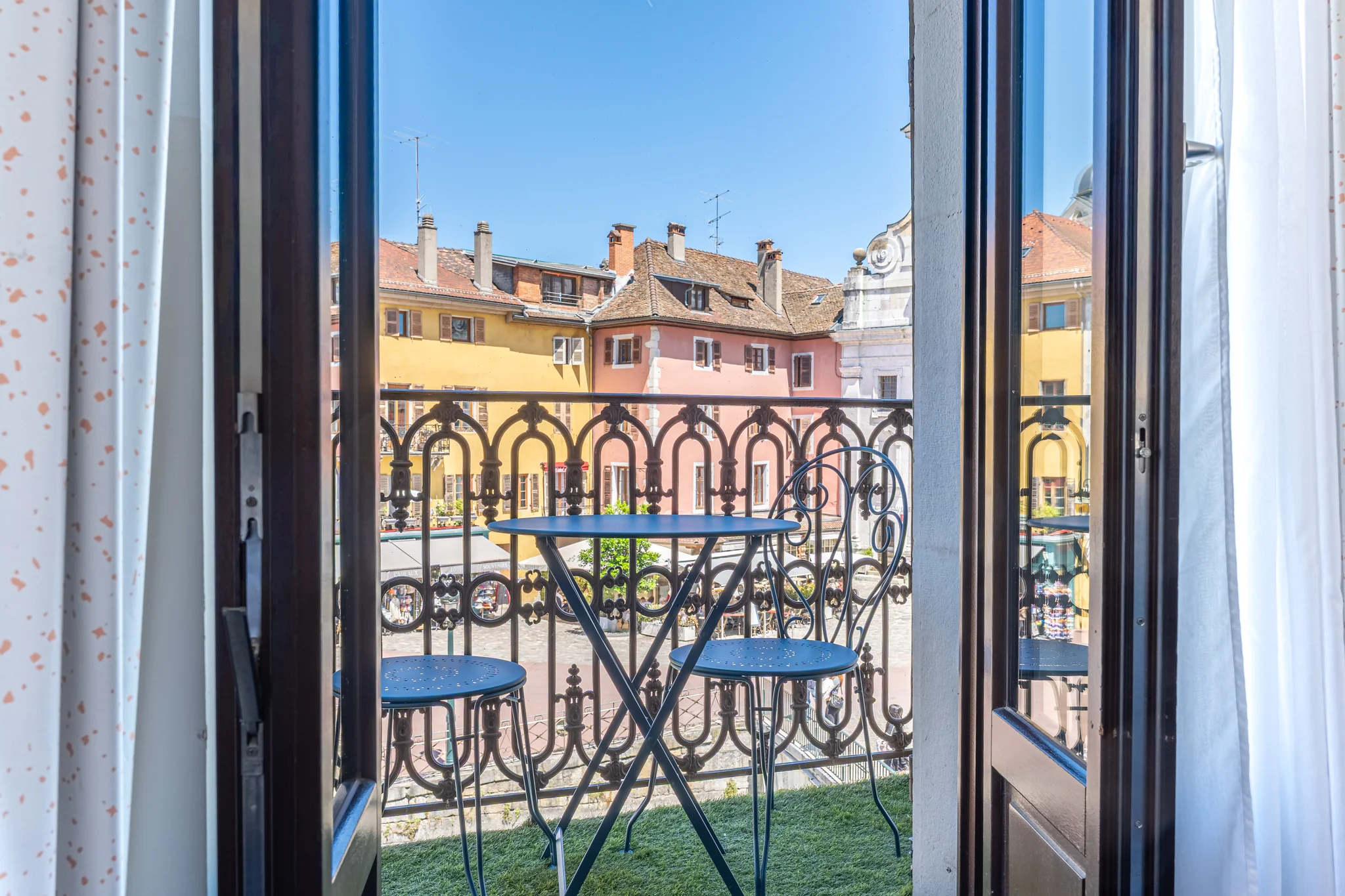 Balcone della Suite Imperatore con tavolo e sedie di fronte alle facciate del centro storico di Annecy
