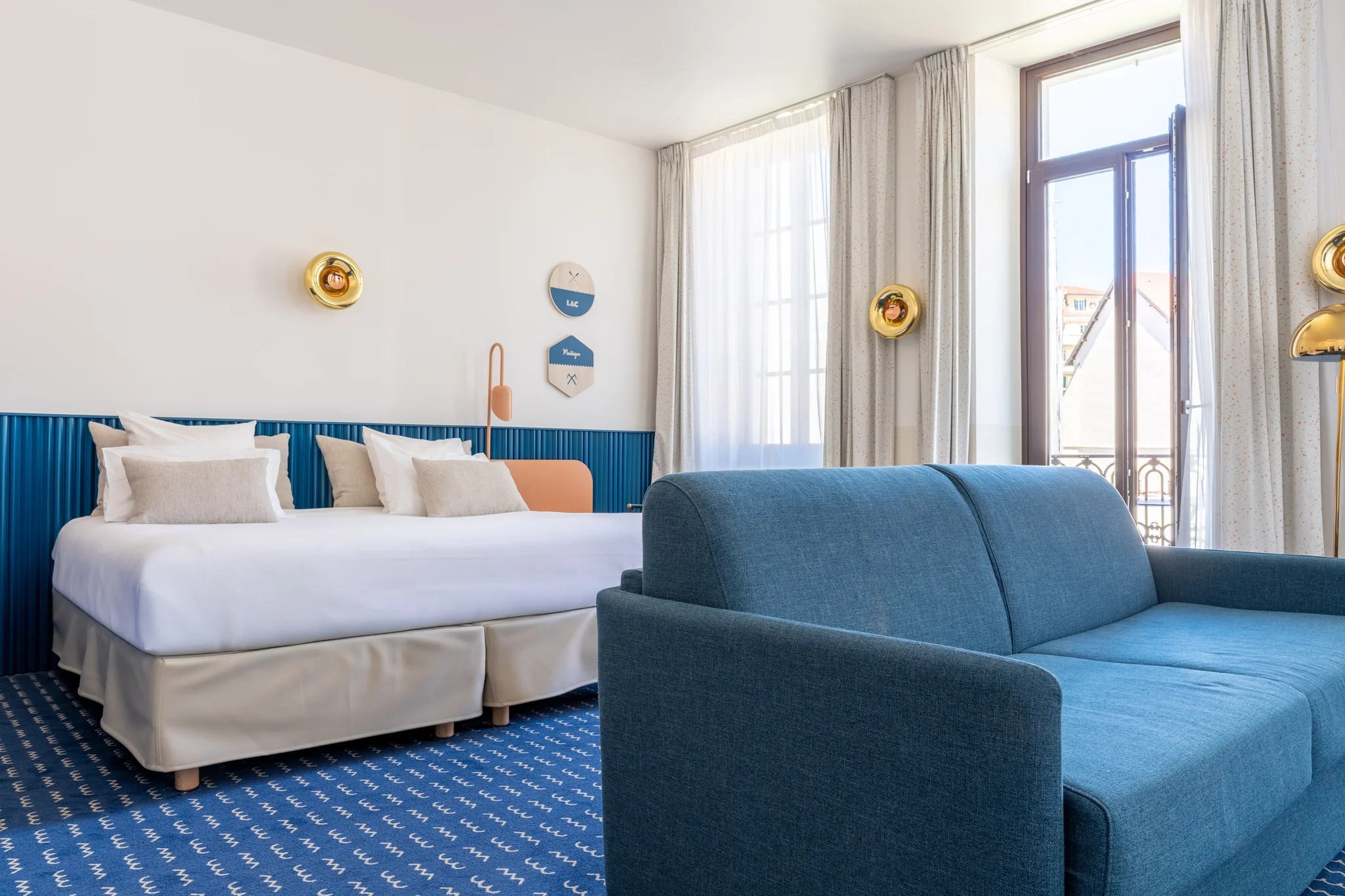 Camera della Suite Imperatore con letto matrimoniale, testiera blu e divano
