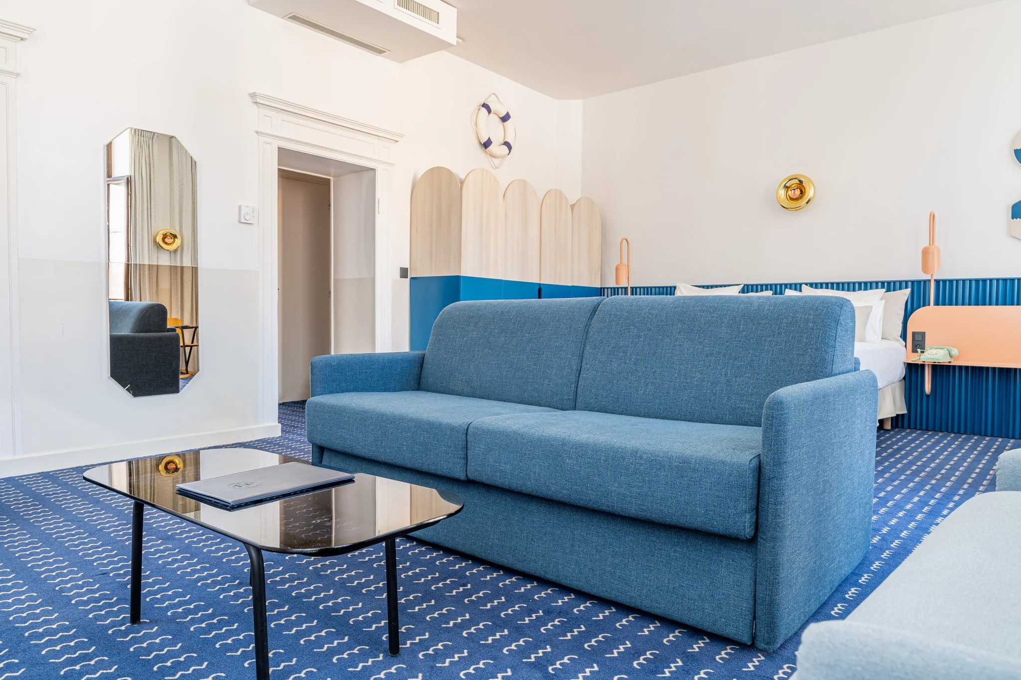 Salotto della Suite Imperatore con divano blu, tavolino e specchio a parete