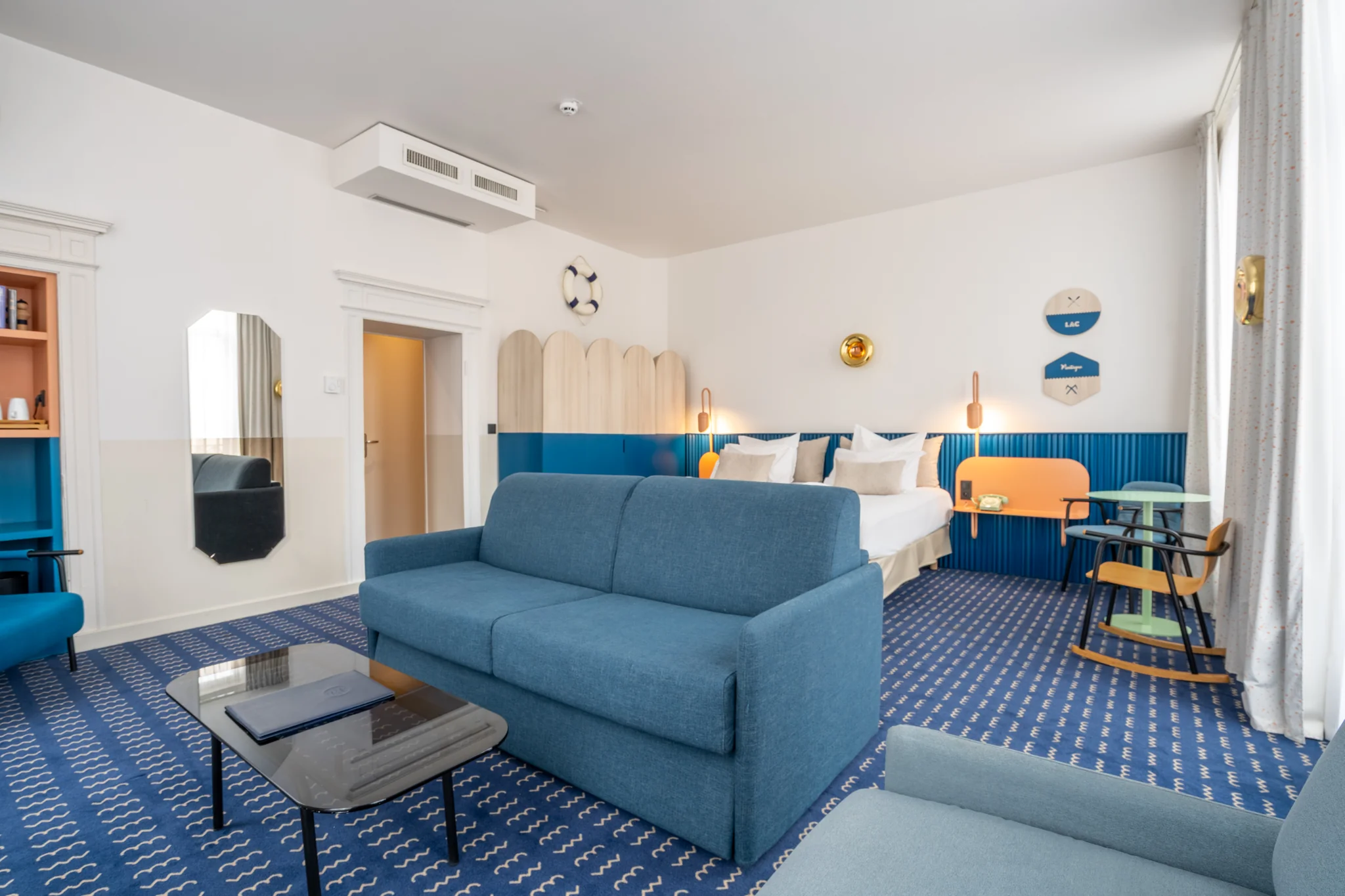 Angolo salotto della Suite Imperatore con vista sul letto e sull’arredo blu